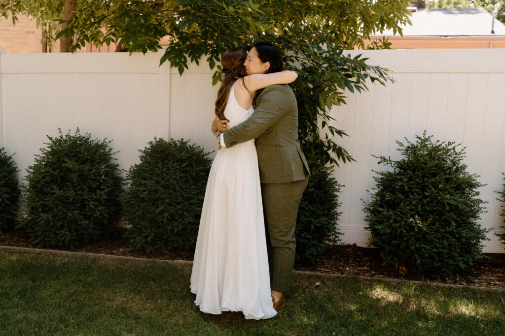 Bride's hugging during first look on wedding day at Sunrise Amphitheater 