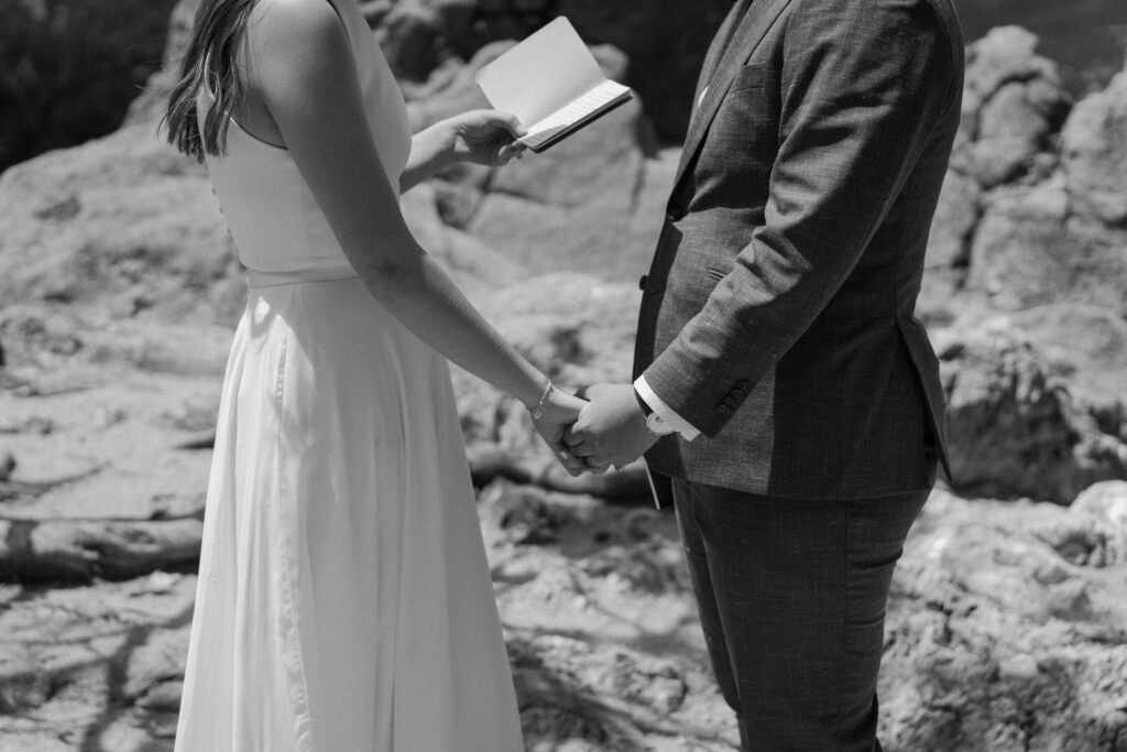 Couple holding hands during vows on wedding day at Sunrise Amphitheater 