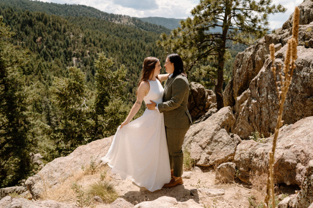 Couple smiling at each other on a cliff on wedding day