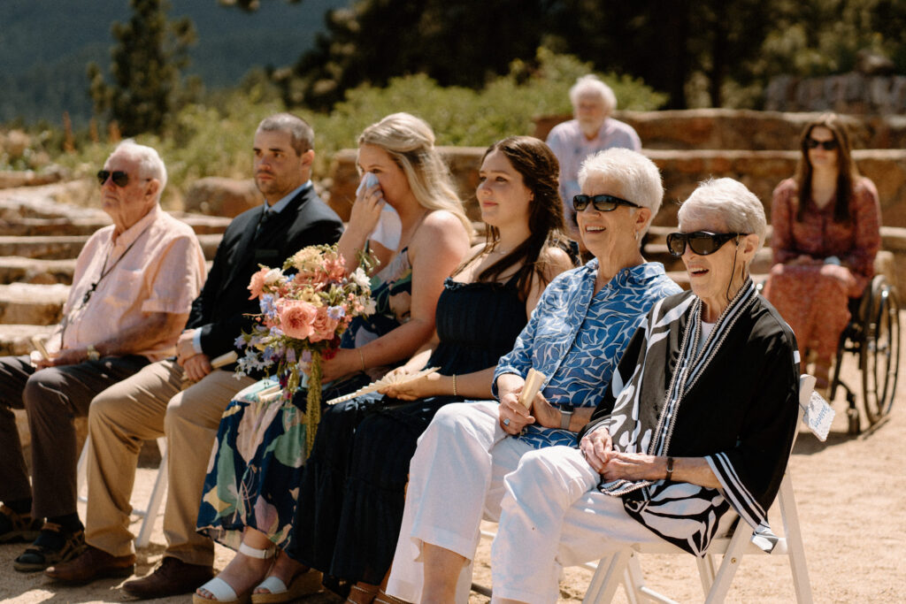 Wedding guests smiling during ceremony at Sunrise Amphitheater  