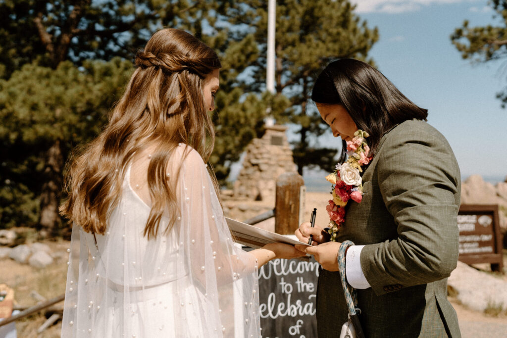 Bride signing marriage license after ceremony at Sunrise Amphitheater 