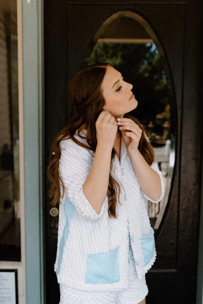Bride putting earrings in on wedding day at Sunrise Amphitheater 