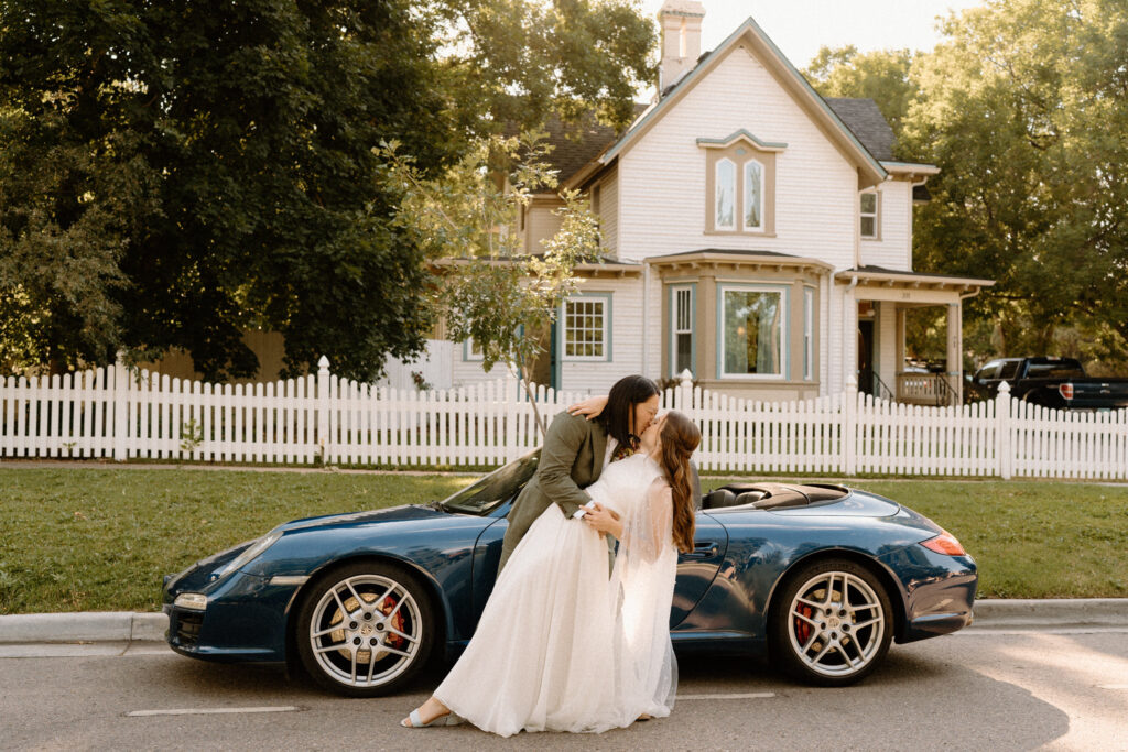 Couple kissing outside of house on wedding day