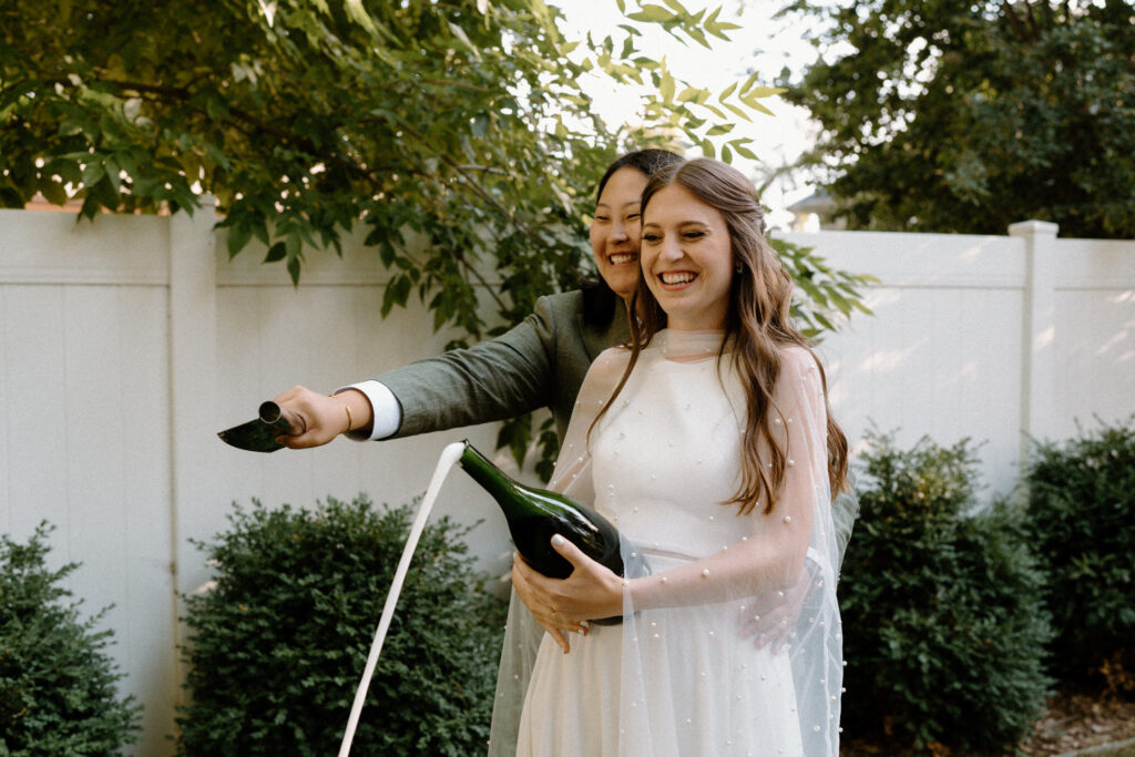 Couple popping champagne during a wedding reception
