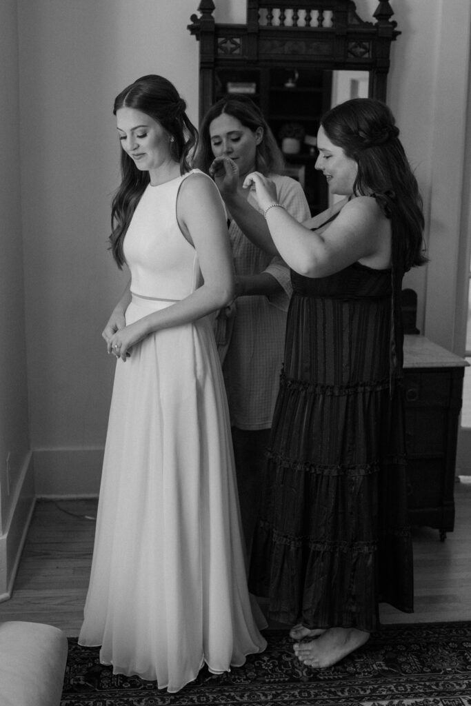 Bridesmaid's putting on bride's dress at Sunrise Amphitheater 