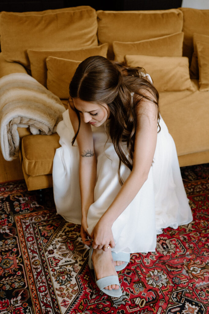 Bride putting on wedding shoes at Sunrise Amphitheater 