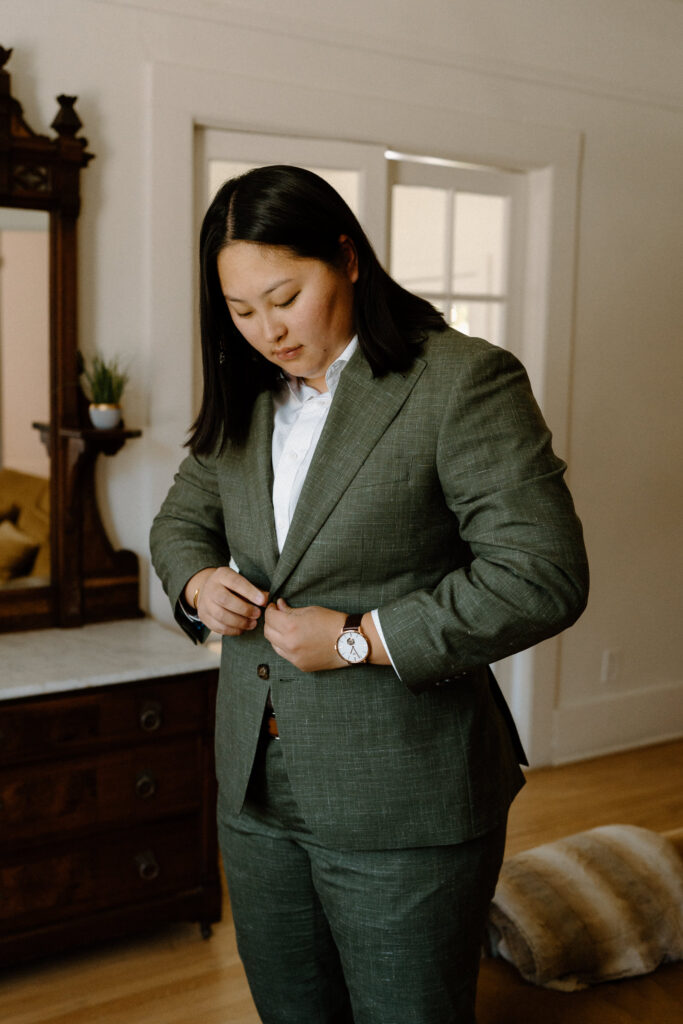 Bride buttoning jacketing on wedding day at Sunrise Amphitheater 