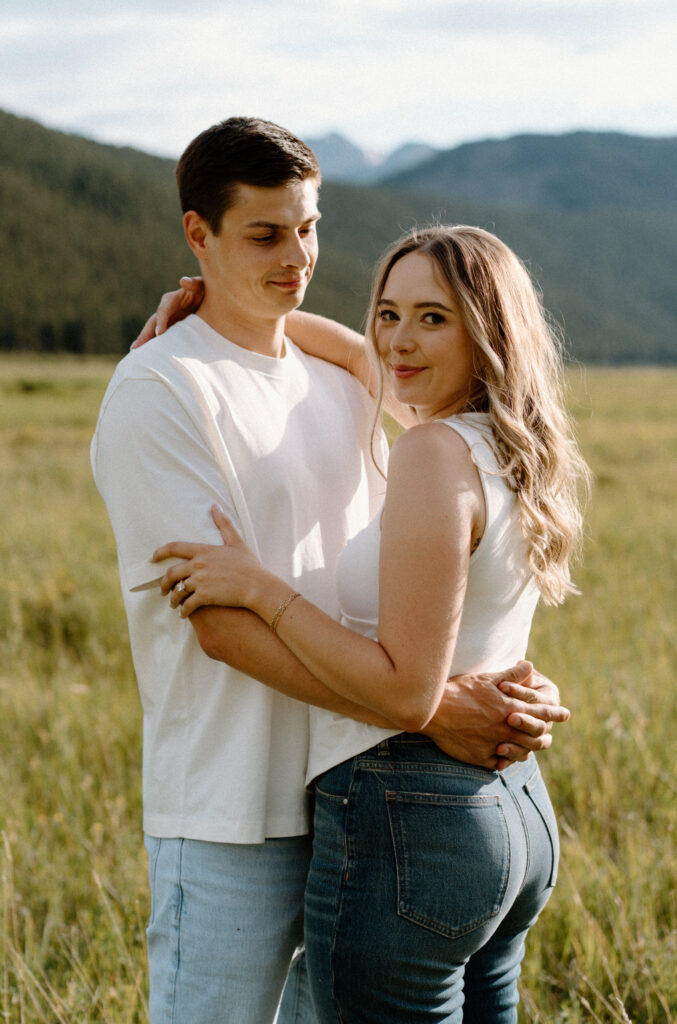 Couple smiling at the camera during an engagement session at Rocky Mountain National Park