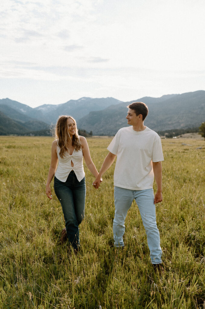 Couple laughing with each other while hiking at Rocky Mountain National Park during engagement session