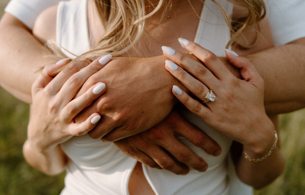 Couple hugging each other showing engagement ring during a session at Rocky Mountain National Park