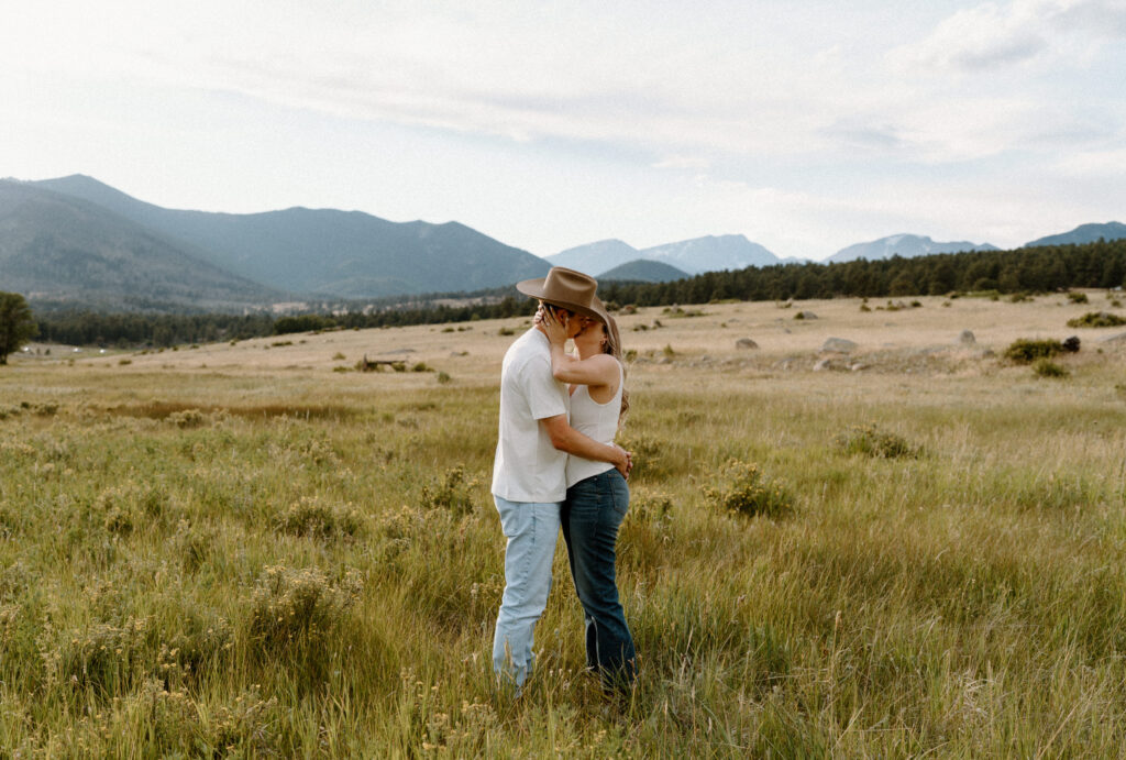 Couple kissing in a field during engagement session at Rocky Mountain National Park