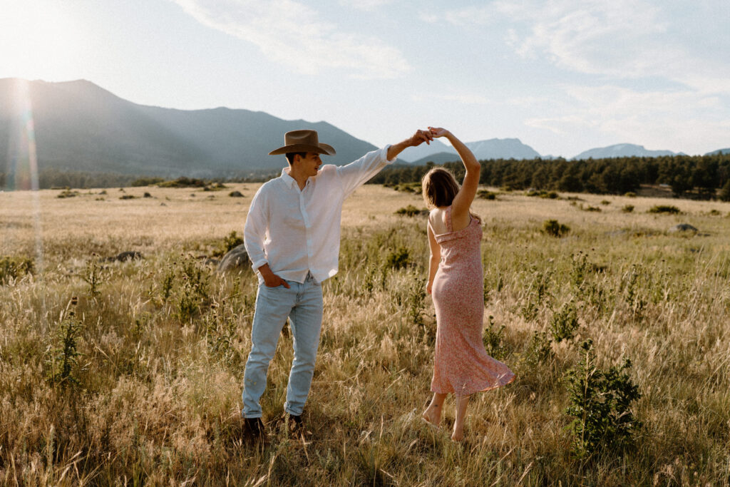 Fiancé twirling fiancée during an engagement session at Rocky Mountain National Park