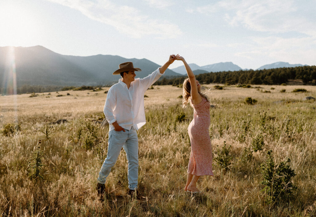 Couple laughing and spinning during an engagement session at Rocky Mountain National Park