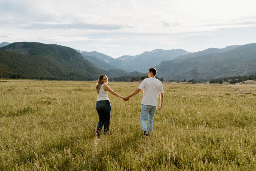 Couple walking in a field during engagement session at Rocky Mountain National Park