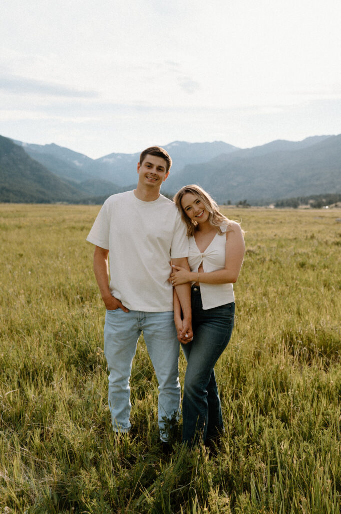 Couple hugging in a field in Rocky Mountain National Park during an engagement session