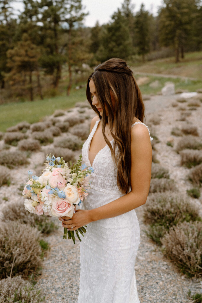 Bride looking at her bouquet on wedding day at Woodlands