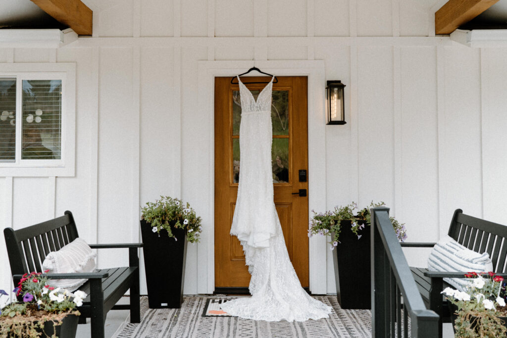 Bride's dress hanging on door frame from a wedding at Woodlands