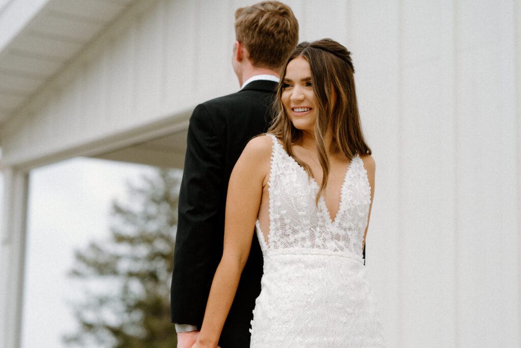 Bride smiling during first touch with groom on wedding day at Woodlands