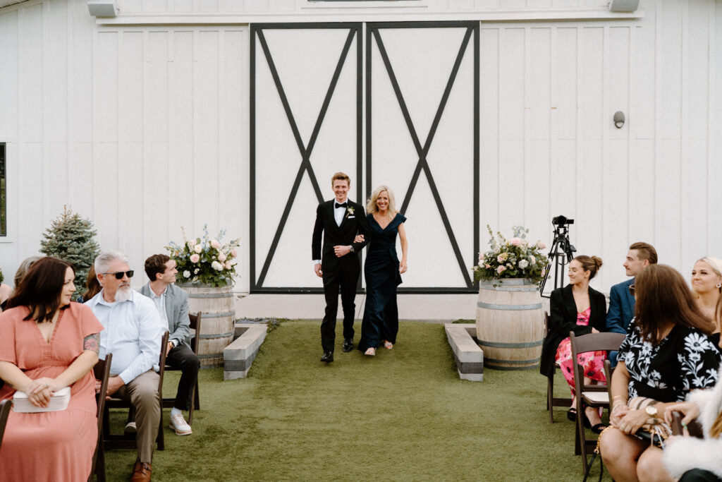 Groom and mom walking down the aisle on wedding day at Woodlands