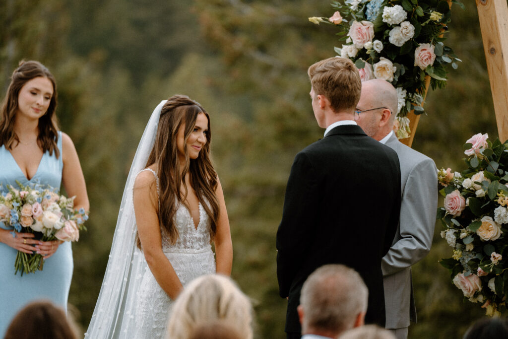 Bride smiling at groom during wedding ceremony at Woodlands