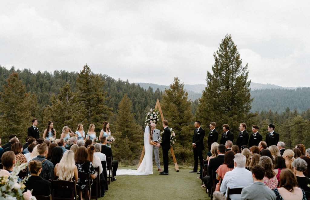 Bride and groom standing at the alter holding hands at Woodlands