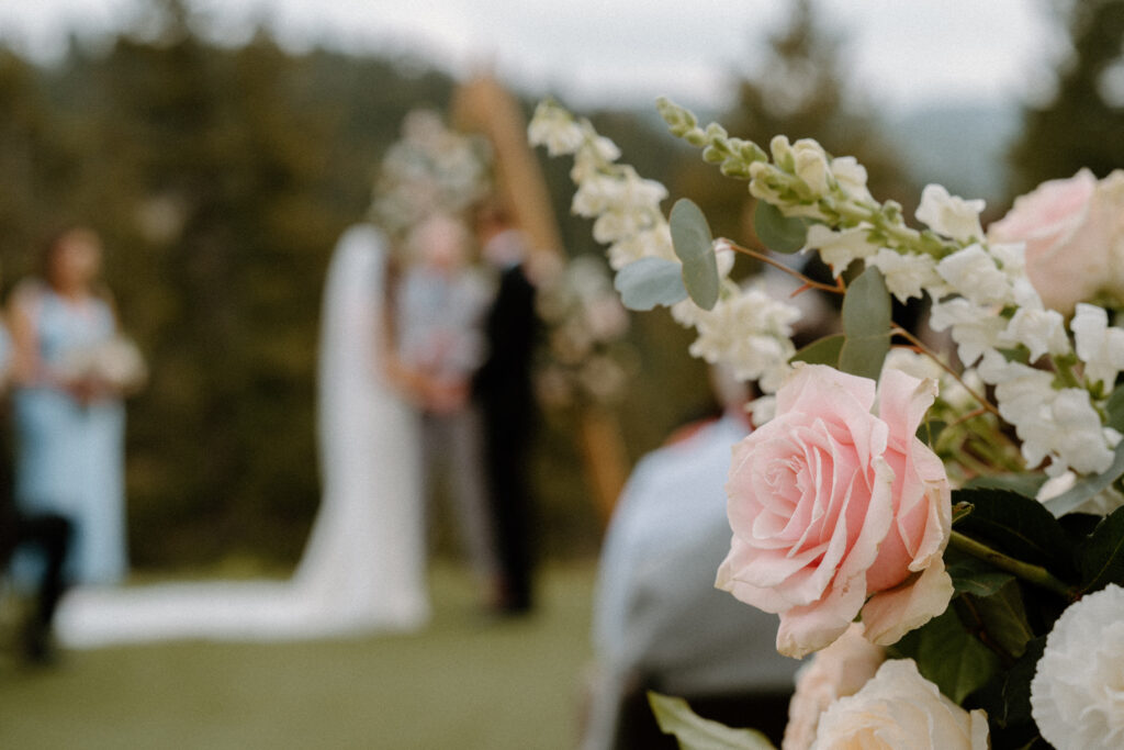 Bride and groom standing at the alter with florals at Woodlands