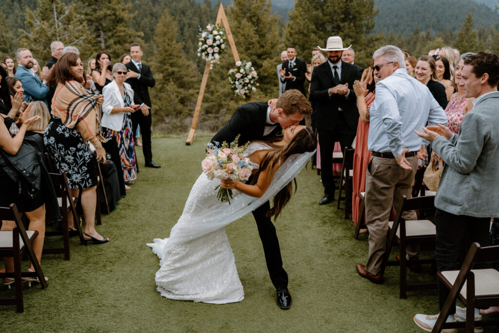 Groom dipping bride after ceremony on wedding day at Woodlands