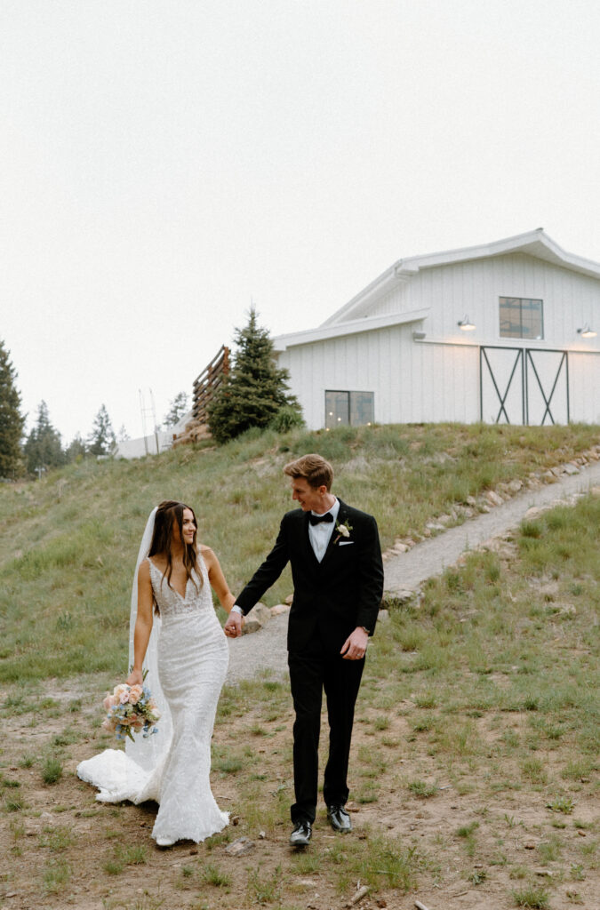 Bride and groom walking down a path at Woodlands on wedding day