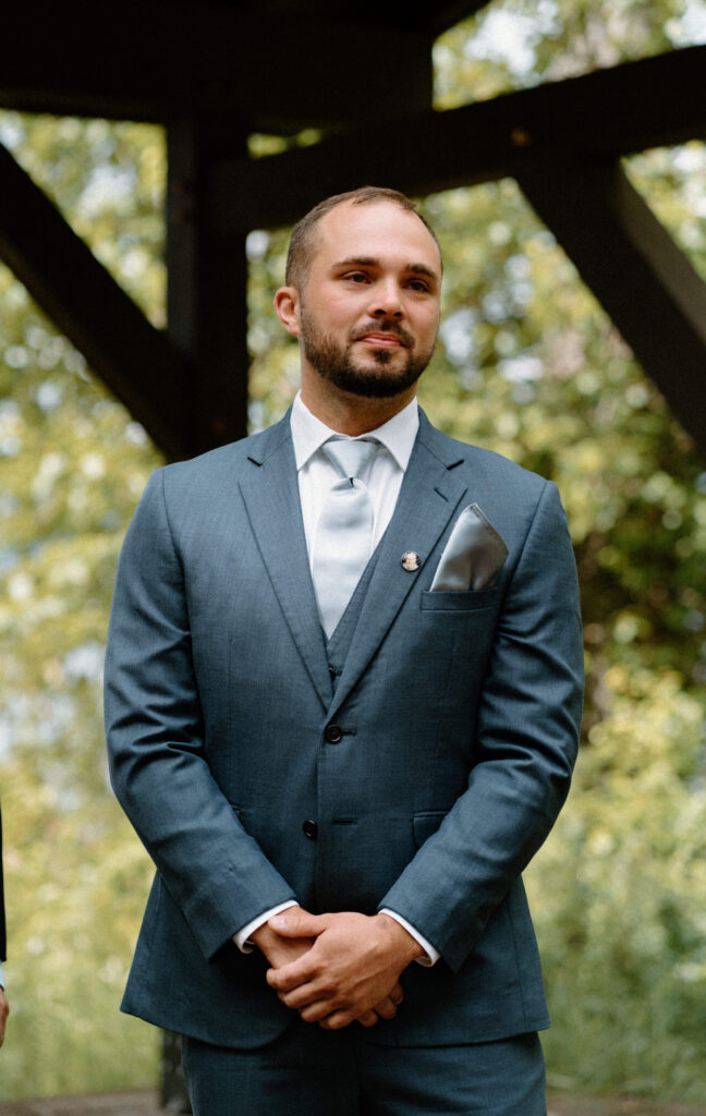 Groom watching bride walking down the aisle during an elopement at Glacier National Park