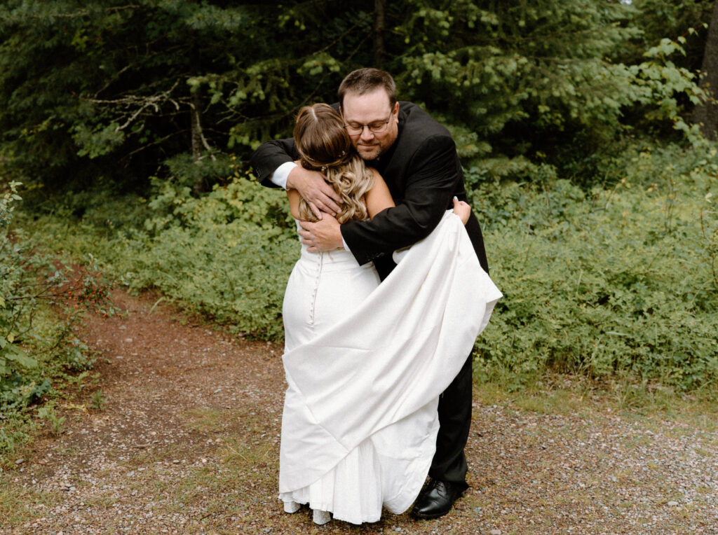 Bride and dad hugging during first look at an elopement in Glacier National Park