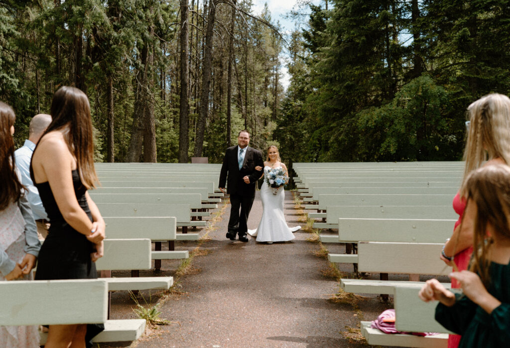 Bride and dad walking down the aisle during an elopement at Glacier National Park