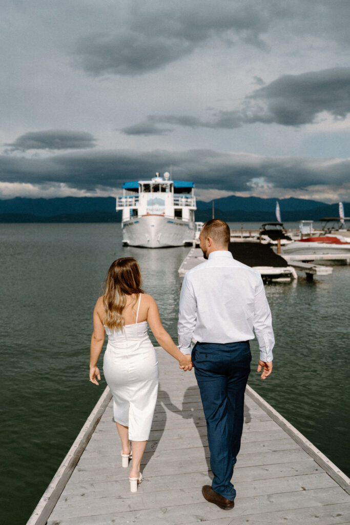 Couple walking on a dock during their rehearsal dinner in Montana