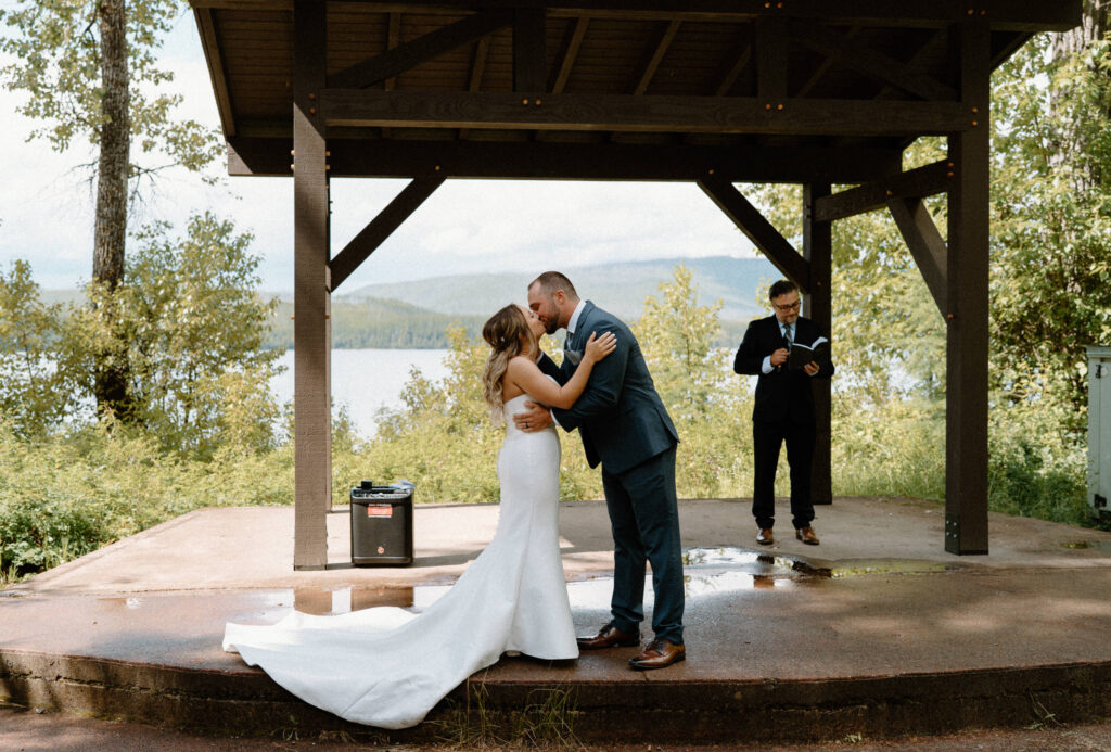 Bride and groom kissing during ceremony at an elopement at Glacier National Park