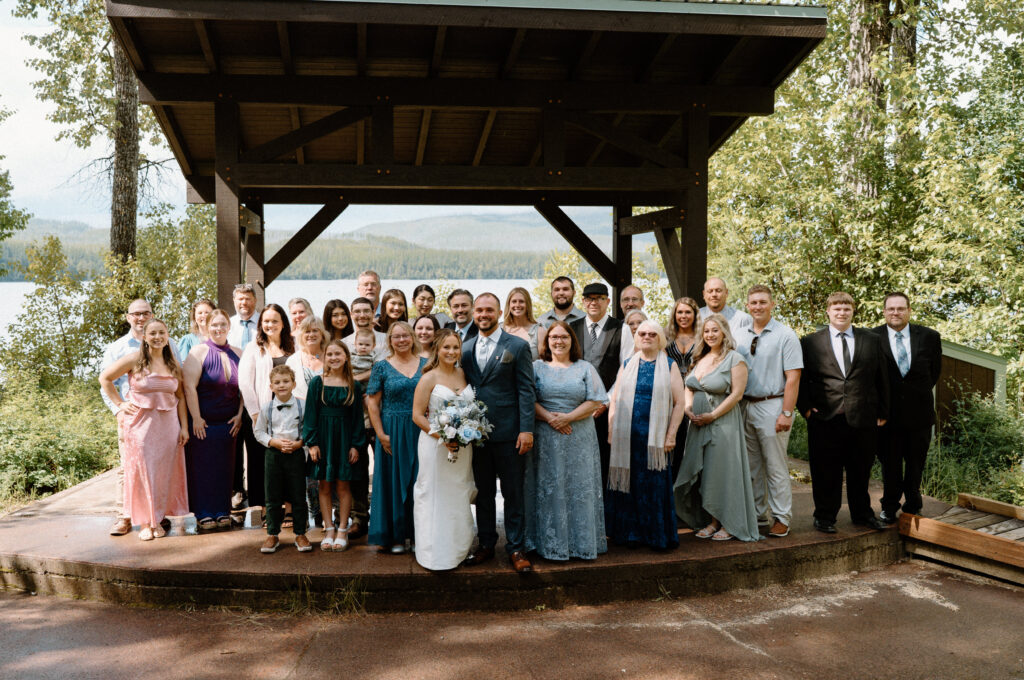 Bride and groom with guests smiling during an elopement at Glacier National Park