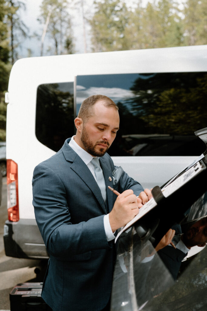 Groom signing marriage license during an elopement at Glacier National Park