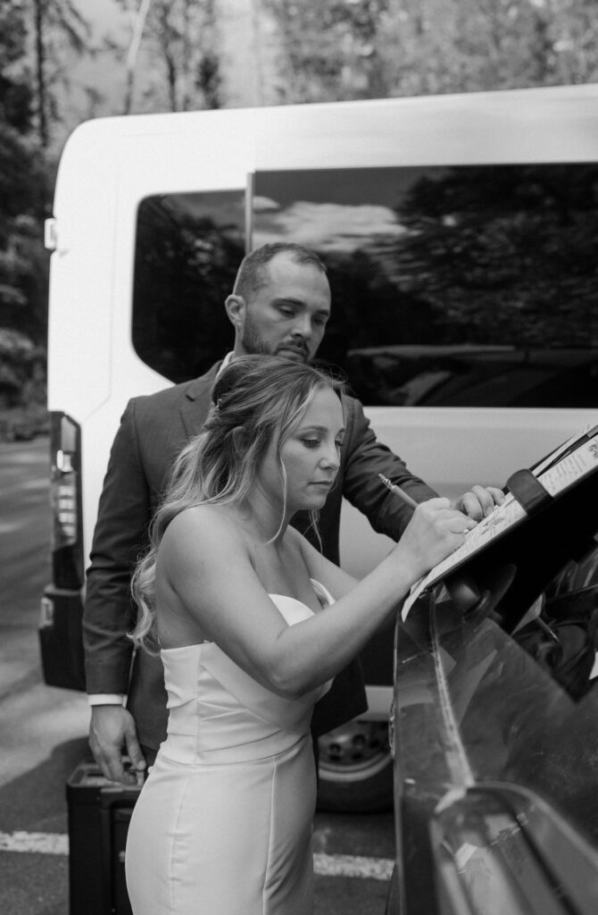 Bride signing marriage license during an elopement at Glacier National Park