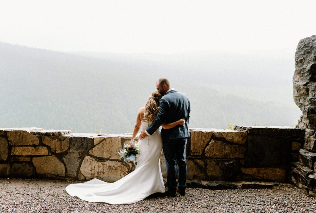 Groom kissing bride's head during an elopement at Glacier National Park