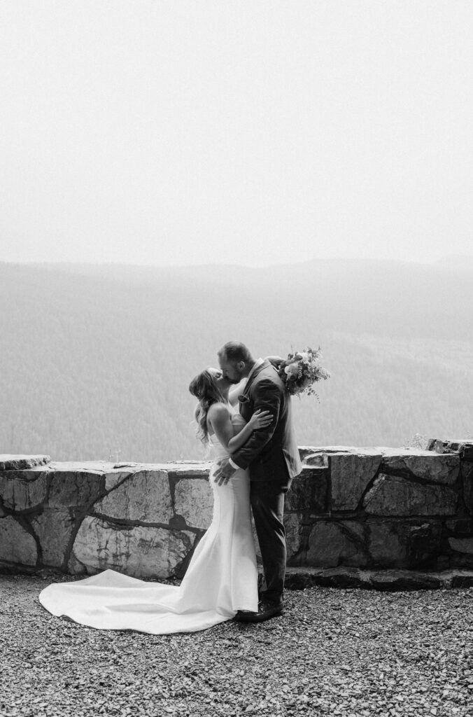 Bride and groom kissing in a tunnel at Glacier National Park during an elopement