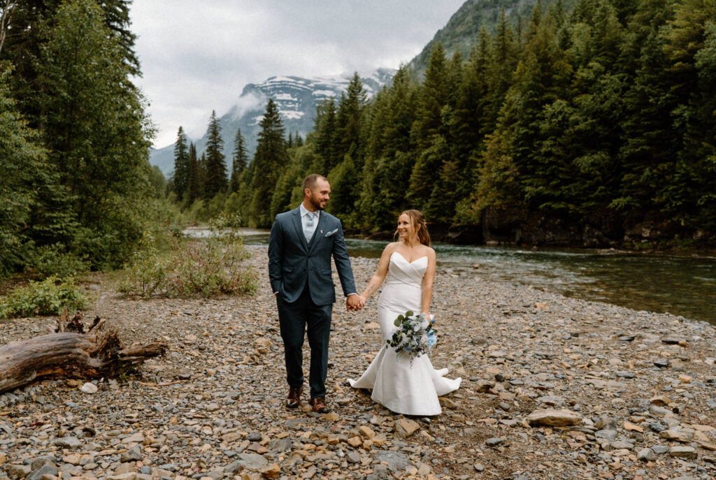 Bride and groom walking in Glacier National Park