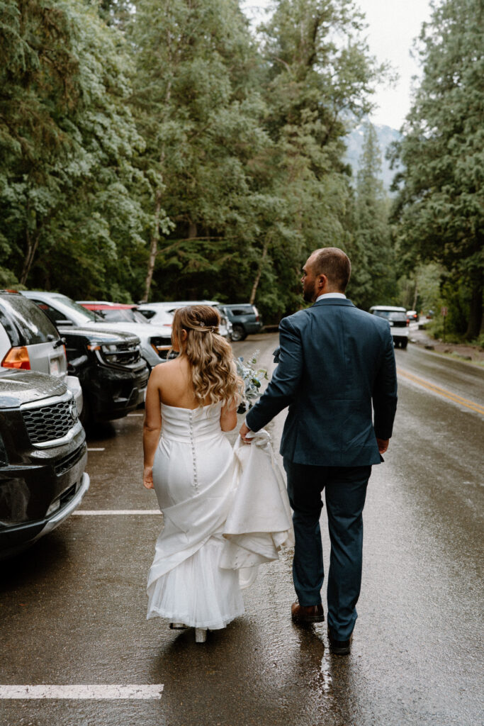 Bride and groom walking to their car during an elopement in Glacier National Park