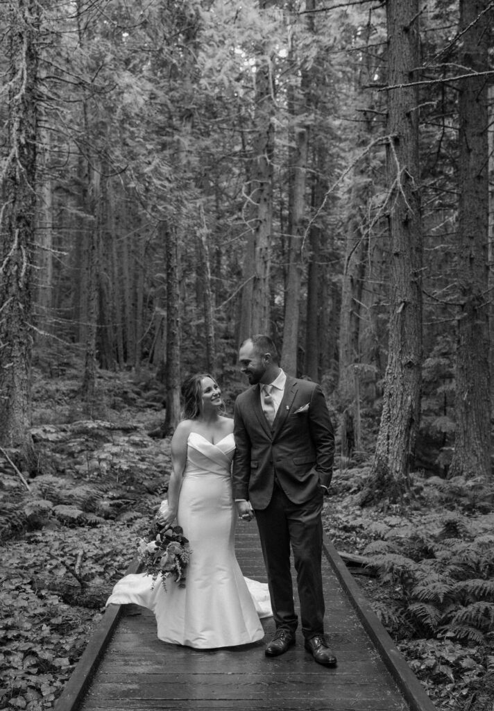 Bride and groom walking on a path in Glacier National Park