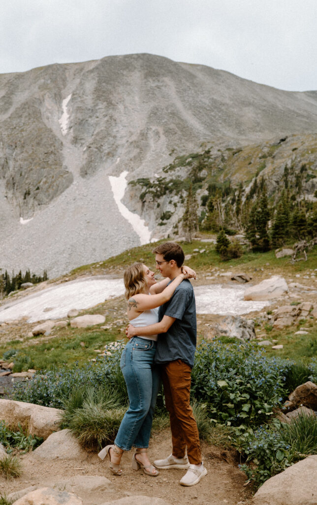 Couple hugging at Lake Isabelle during an engagement session