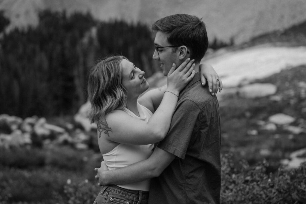 Couple hugging on a hike during an engagement session at Lake Isabelle