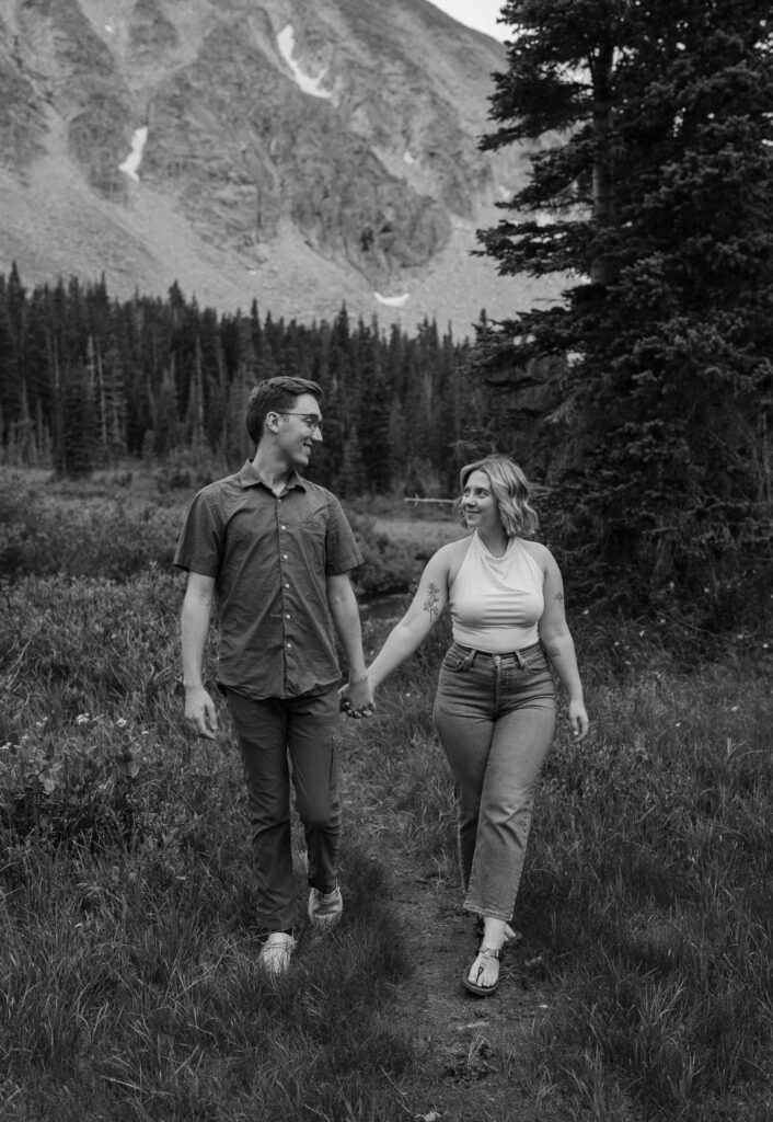 Couple smiling at each other on a hike at Lake Isabelle 