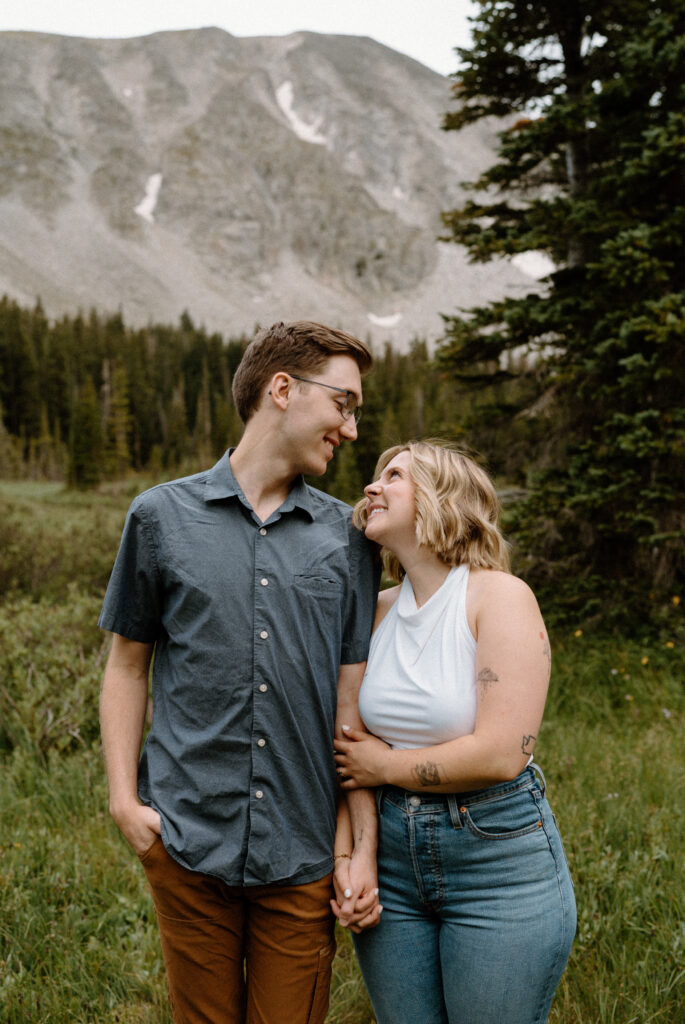 Couple smiling at each other during an engagement session at Lake Isabelle
