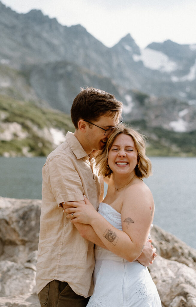 Couple laughing during an engagement session at Lake Isabelle