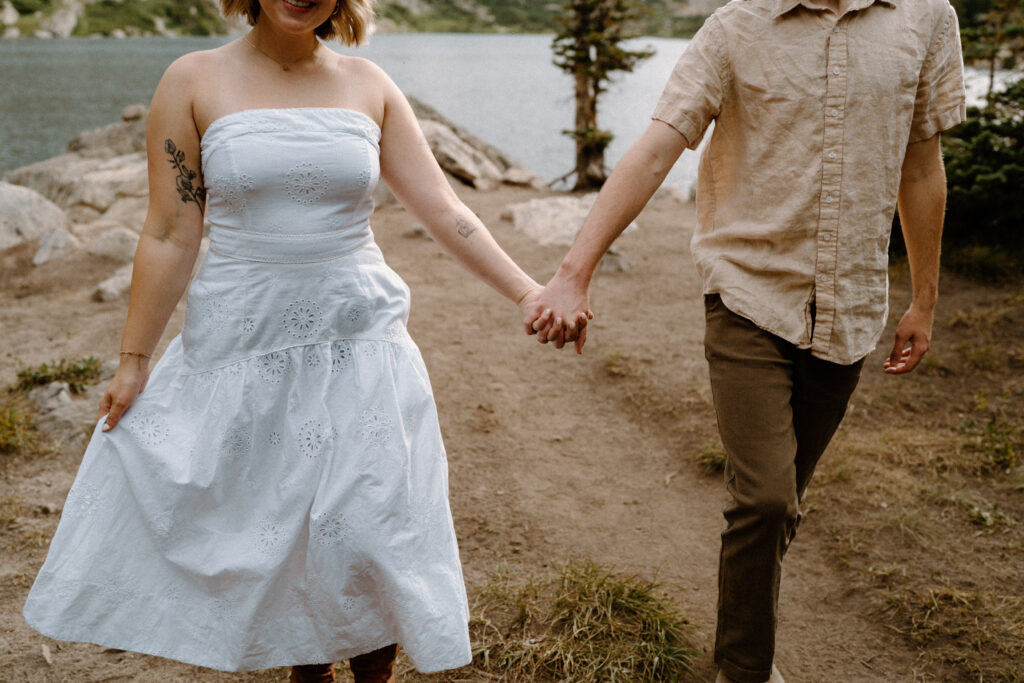 Close-up of couple holding hands at Lake Isabelle during engagement session 