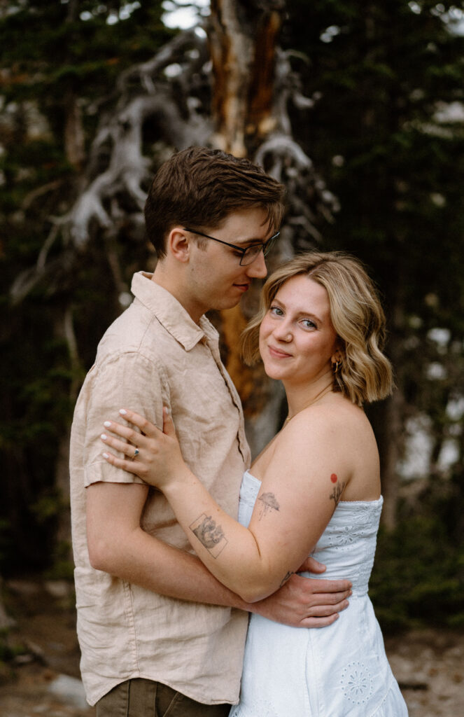 Fiancée smiling at the camera during an engagement session at Lake Isabelle