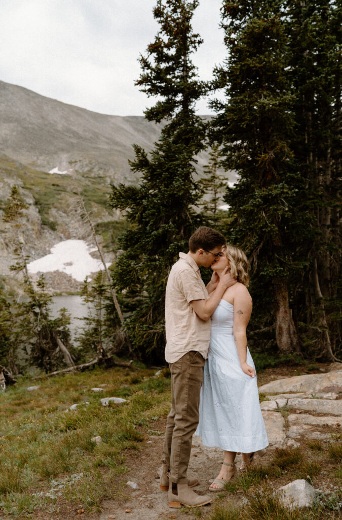 Couple kissing on a path during an engagement at Lake Isabelle