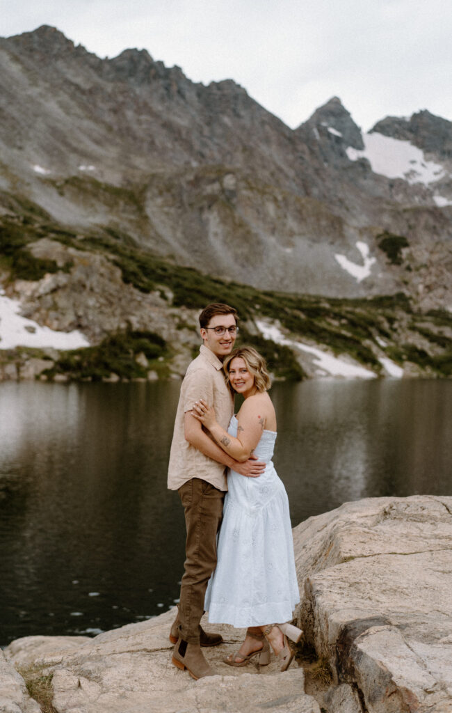 Couple smiling at the camera during an engagement session at Lake Isabelle
